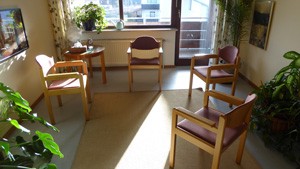 Zimmer mit Stühlen, Sonnenlicht fällt durch das Fenster - Bild zeigt die Atmonsphäre im Beratungszimmer